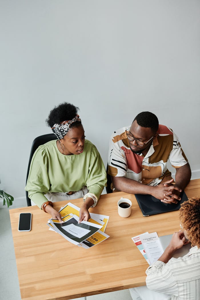 High angle view of diverse coworkers collaborating at a shared office table.